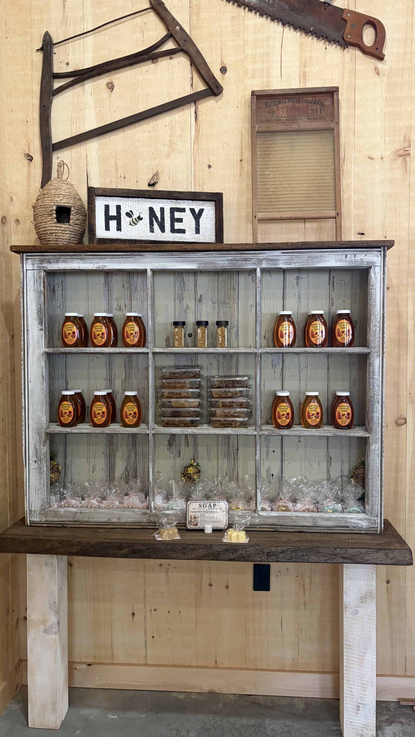 Honey jars, bee pollen, and honeycomb display in a window cabinet