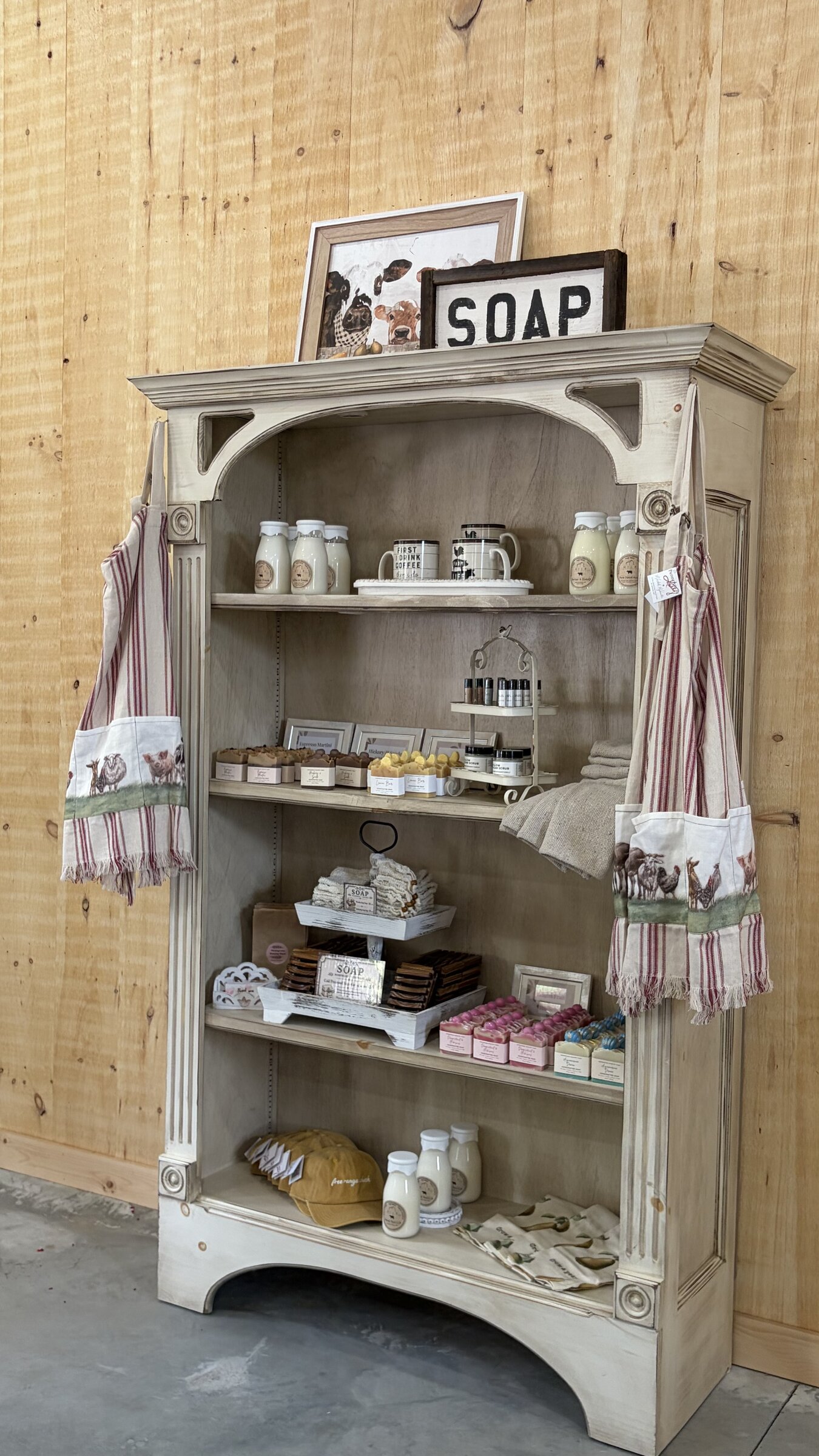 Vintage cabinet displaying handmade soaps, towels, and farm goods