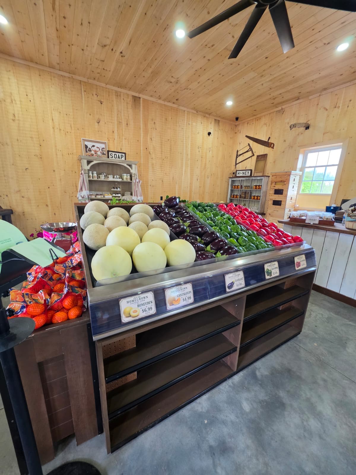 Country store produce display with melons, peppers, and eggplant
